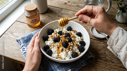 Healthy bowl of cottage cheese with fresh blackberries and honey.