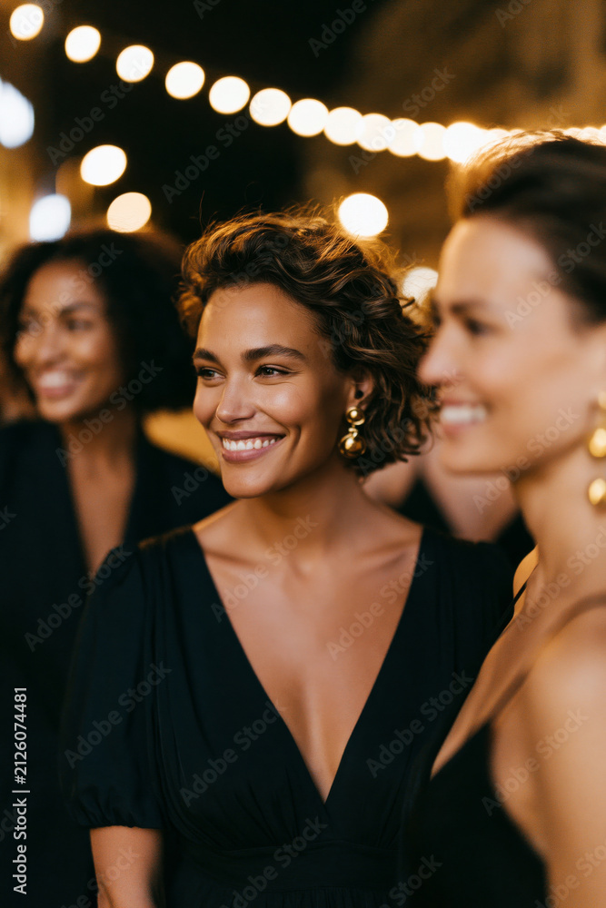 Fototapeta premium Women enjoying a chic urban night gathering, glowing city lights, stylish attire, natural social connection, clean modern composition,, with crystal clear water