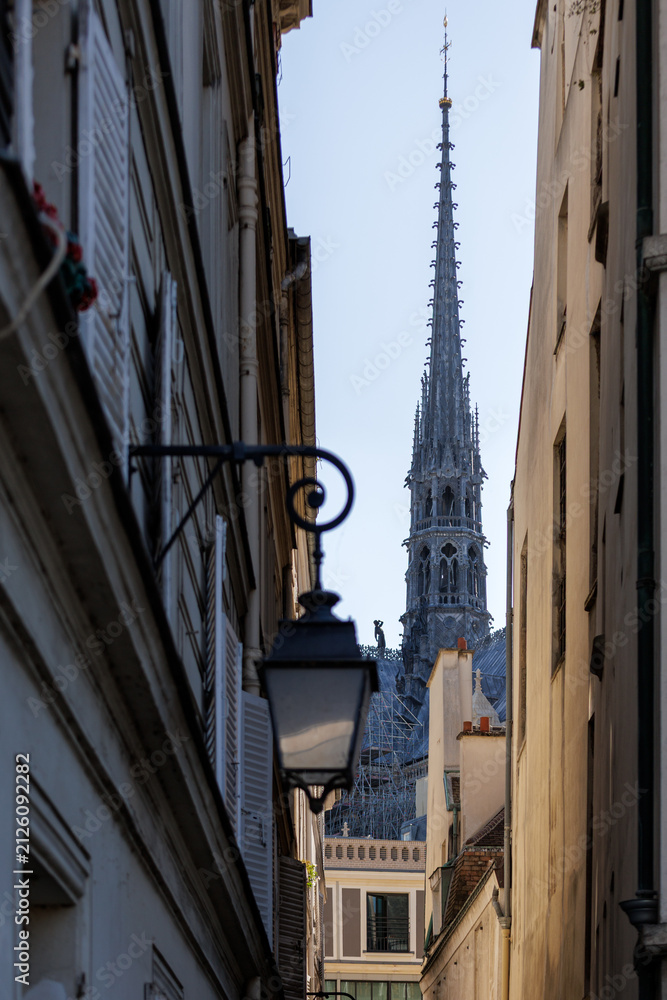 Fototapeta premium Sainte Chapelle Spire Framed by Narrow Historic Paris Street Buildings