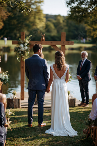 Breathtaking outdoor warm season marriage ceremony beside a lake, bride and groom at the altar, scenic reflections, warm sunlight