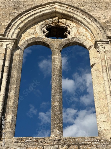 Gothic stone window frame against blue sky with clouds, La Flotte, Nouvelle-Aquitaine, France, July 2025