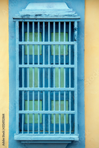 Window with Blue Bars on Yellow Wall