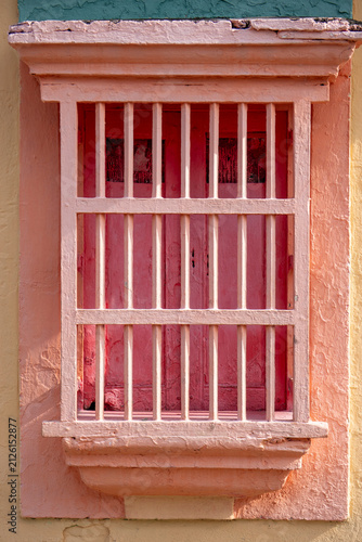 Colonial Style Window with Bars on Yellow Wall