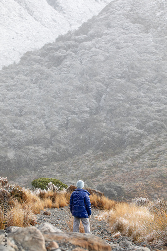 Traveler admiring a snowy mountain landscape during a winter adventure
