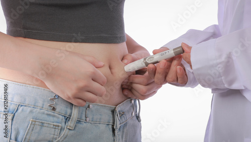 Konstfotografi Focused patient receives medical weight loss injection in belly abdomen assisted
