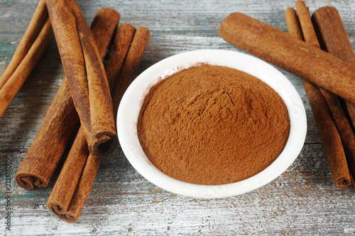 Cinnamon sticks and powder in bowl