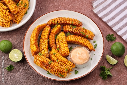 Corn ribs served with flavorful seasoning and dipping sauce. Fresh corn on the cob cut into rib-shaped wedges, baked, roasted, or air-fried until golden and tender.