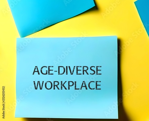 Paper note on yellow background with words AGE-DIVERSE WORKPLACE, refers to multi-generational workforce and age diversity in environment in office or organization