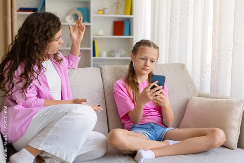 Canvastavla Frustrated mother scolding her daughter, who ignores her and stays focused on he