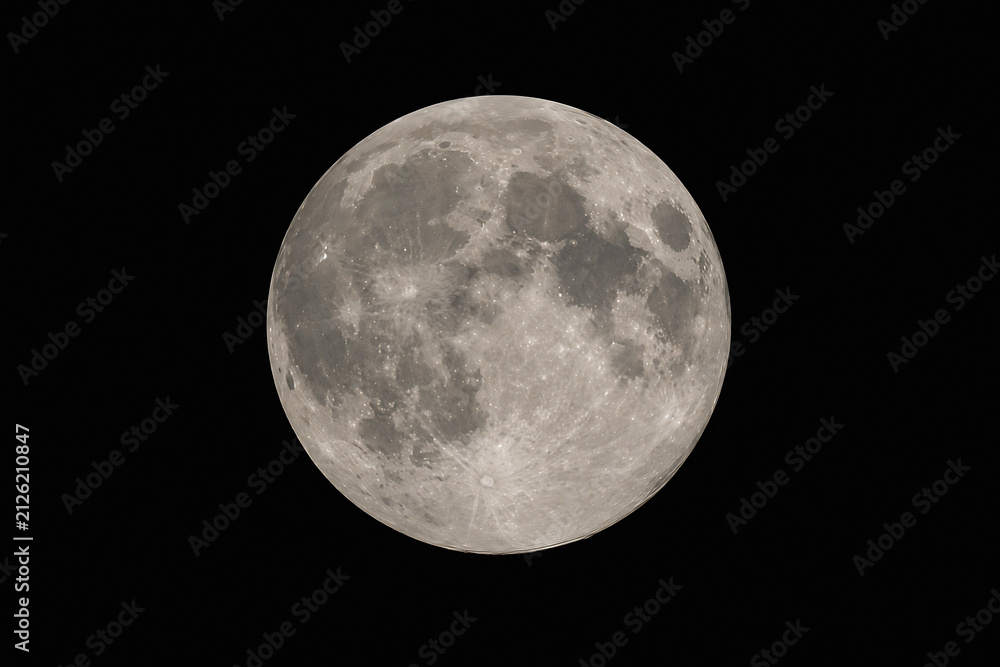 Fototapeta premium A full moon is visible against a black night sky.