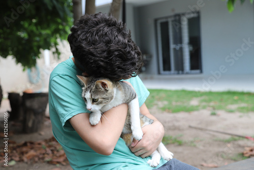Friendship and love between a young person and their pet. Teenager hugging a cat outdoors: f
