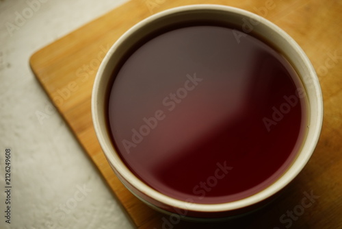 ceramic cup with black ceylon tea on wooden board