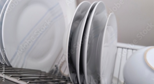 Obraz na płótnie Clean plates drying on a dish rack in a kitchen after being washed and rinsed