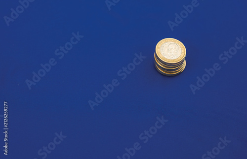 Stack of Euro Coins on Blue Background. European Economy, Finance and EU Budget Concept. Minimal. Copy Space. Shallow Depth of Field.