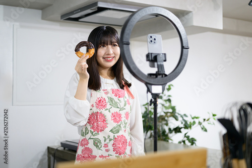 スマホでスイーツ撮影をする日本人女性