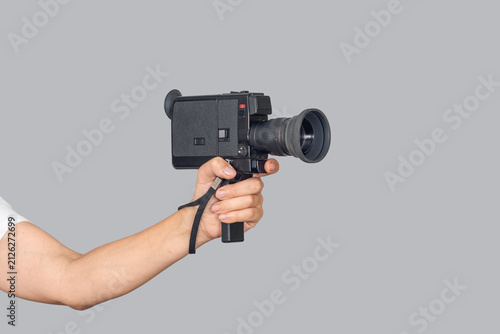 Female hand using vintage video camera on gray background with copy space. Side view, Vintage technology