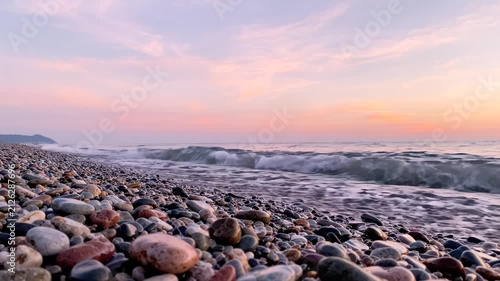 Pebble Beach at Sunset with Gentle Ocean Waves Rolling Ashore