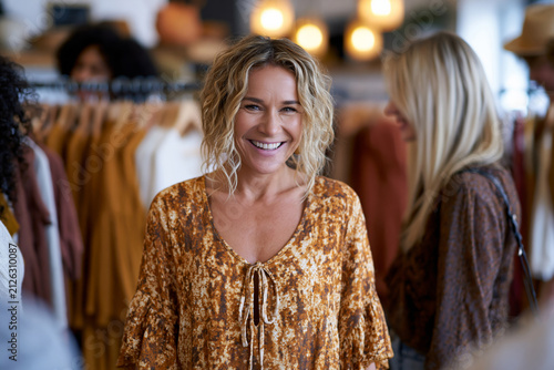 Fashion stylist presenting historically inspired garments to interested customers, organized clothing displays, welcoming boutique environment, rendered in sharp detail with beautiful natural