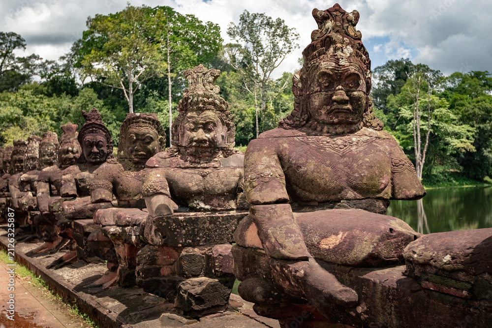 Fototapeta premium Ancient stone guardian statues lining the causeway at the South Gate of Angkor Thom in Siem Reap, Cambodia