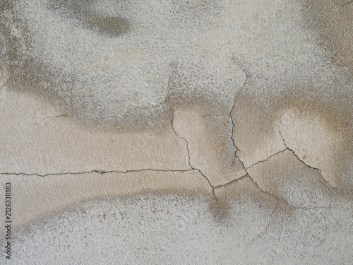 Horizontal fracture on a textured concrete wall showing severe brown water seepage stains