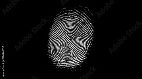 A detailed human fingerprint with whorl patterns set against a black background. Represents biometric security and.