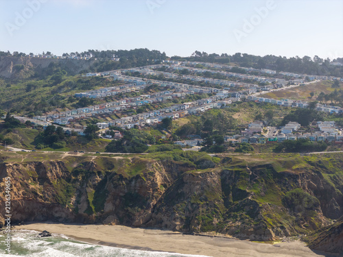 Obraz na plátně Coastal bluff landscape featuring a sandy beach, Pacific Ocean waves, and a hill
