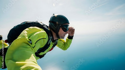 Skydiver in yellow jumpsuit and helmet preparing for free fall adventure outdoors