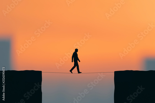 Businessman Silhouette Walking a Tightrope at Sunset