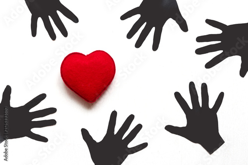 фотографія Black Paper Hands Reaching Out to Red Heart Concept of Charity Support Love and