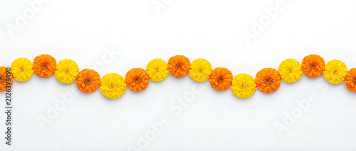 premium alternating yellow and orange marigold flower garland in three smooth waves isolated on white background for indian wedding festival decoration design