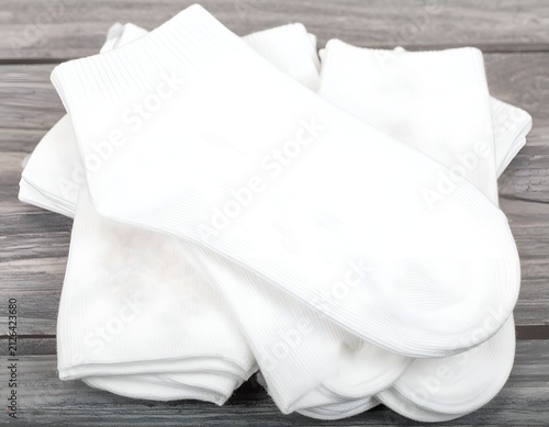 Folded white socks on wood surface.