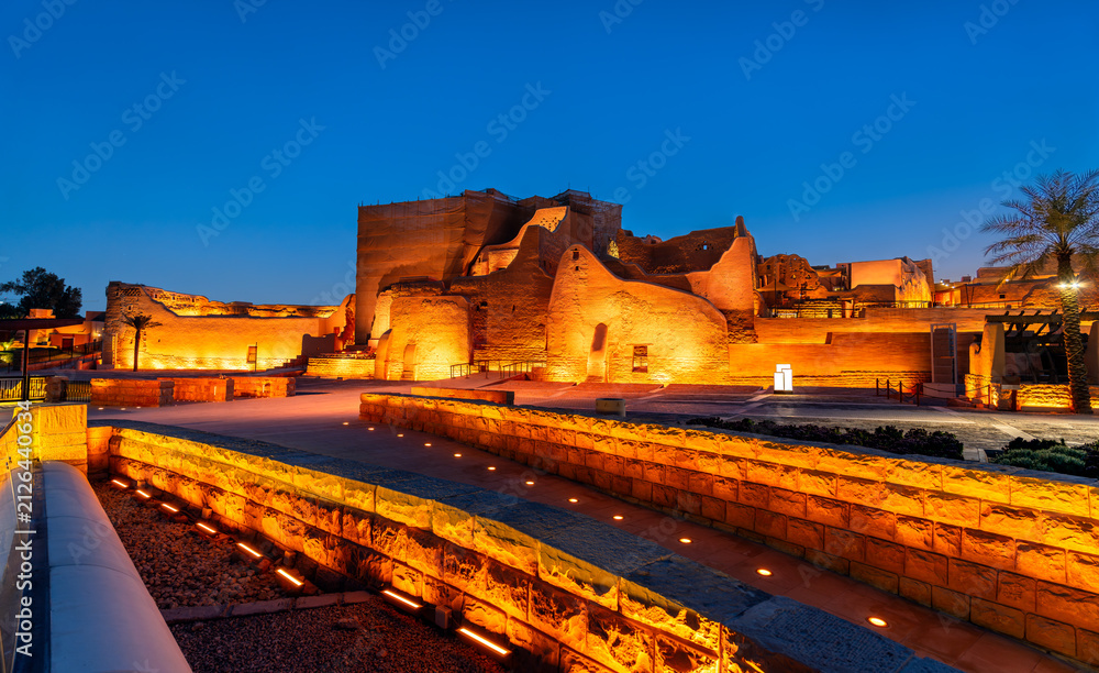Fototapeta premium The illuminated mud brick ruins of At-Turaif World Heritage Site in Diriyah, Saudi Arabia, at dusk.