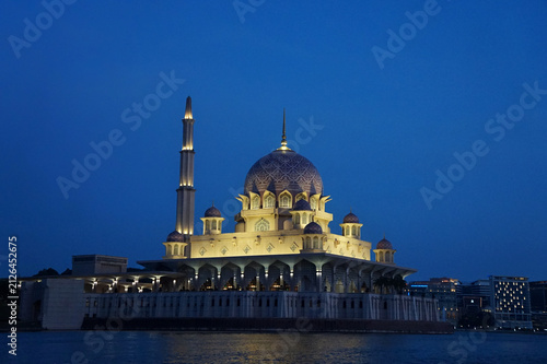 Fotografía PUTRAJAYA, MALAYSIA – AUGUST 10, 2026: The illuminated pink-domed Putra Mosque standing peacefully over the lake during dusk