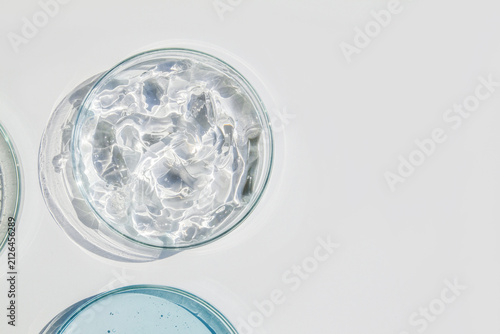 Petri Dish with Thick Transparent Cosmetic Gel on Light Background with Copy Space