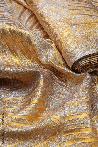 Foto Luxurious gold and silver brocade fashion fabric featuring an elegant wavy leaf pattern, showcasing rich metallic texture and shimmering folds for high-end couture design