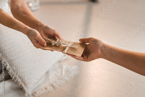 Obraz na plátně A woman in white clothes passes an envelope with a wish to another woman