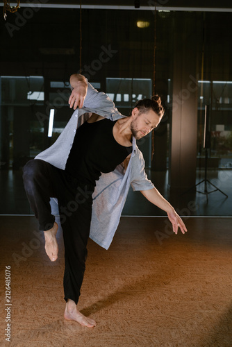 A man performs a randomized movement for yoga at a fitness gym