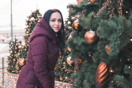 Canvas Print Woman touching Christmas tree decoration on snowy Moscow street