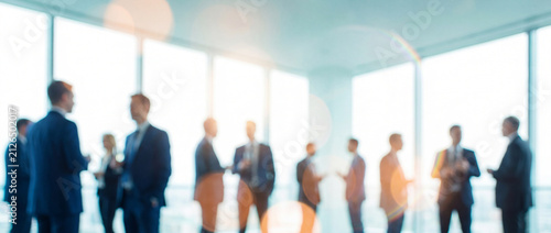 Business networking event in office features blurred silhouettes of corporate executives by large panoramic windows in bright soft blue tones with warm bokeh flare for background designs