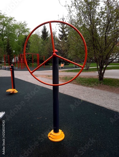 An outdoor fitness wheel installed in a public park.
