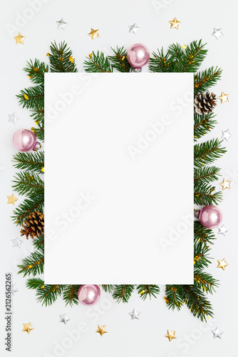 Christmas, New Year vertical frame of fir tree branches, Christmas baubles, decorations on white flat lay background. Perfect for holiday greetings, banners, social media. Copy space
