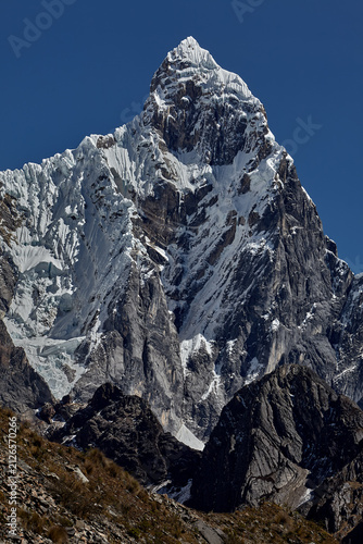 southeast face of Jirishanca reveals its full, imposing grandeur in Peru's Cordillera Huayhuash. Sheer walls of rock and ice rise in near-vertical lines toward a serrated summit, sculpted by centuries
