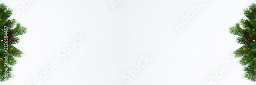 Real fir branches with golden confetti framing clean white background, perfect for holiday banners, greetings, sales ads and winter promo designs. Christmas tree border with copy space.