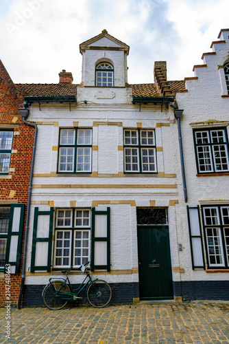 Foto Historic white brick townhouse with green shutters and a bicycle parked outside