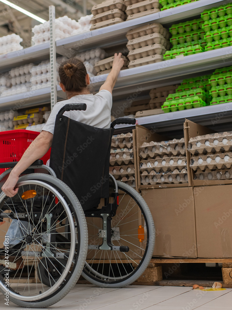 Obraz premium A Caucasian woman in a wheelchair shopping in a supermarket.