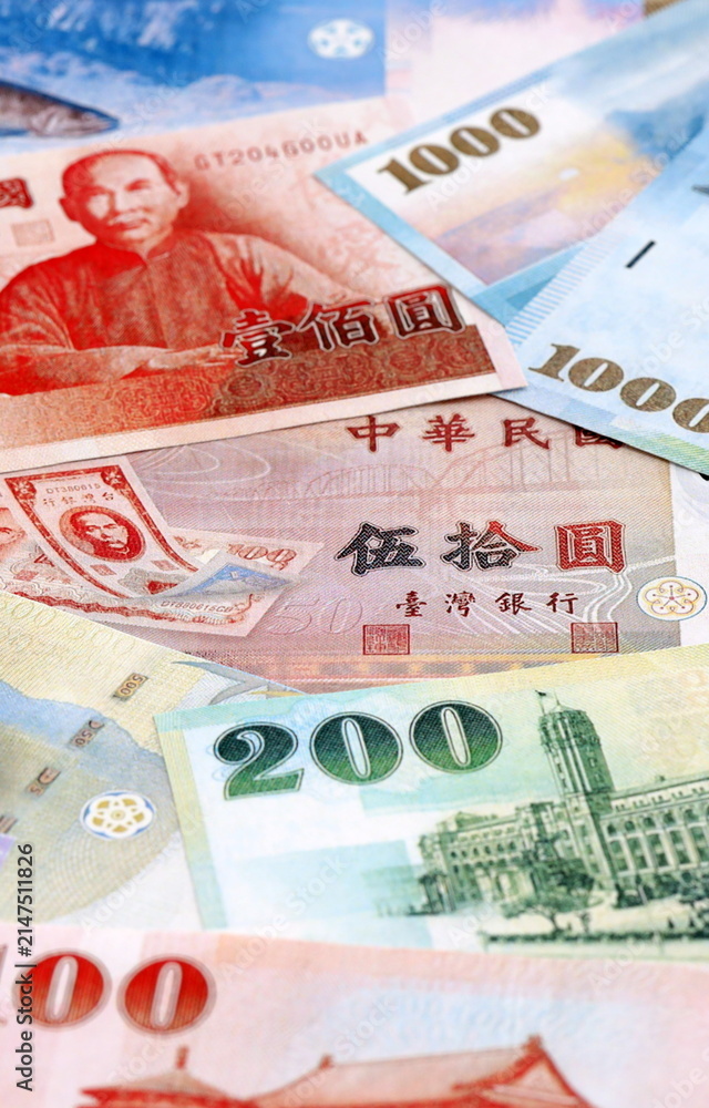 Fototapeta premium Taiwanese dollar money bills pile on table. Taiwan banknotes of TWD currency close up.