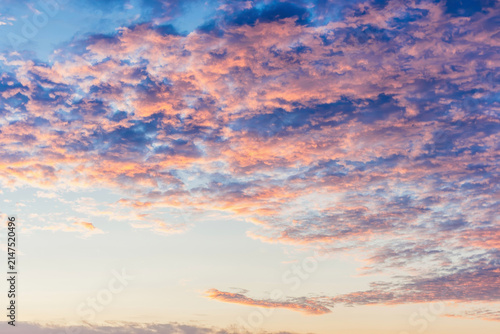Warm sunset clouds in pink and gold spread across a wide sky.