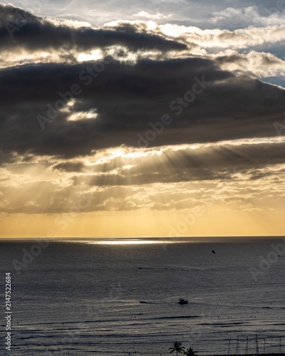Quadro su tela Crepuscular rays break through clouds over the open ocean