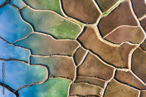 Cuadro en lienzo Top down aerial view of irregular flooded ponds shading from bright blue and gre