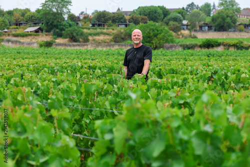 Middle‑aged man enjoying a summer vacation in Burgundy, France, surrounded by expansive vineyards and the tranquil rhythm of rural French life.